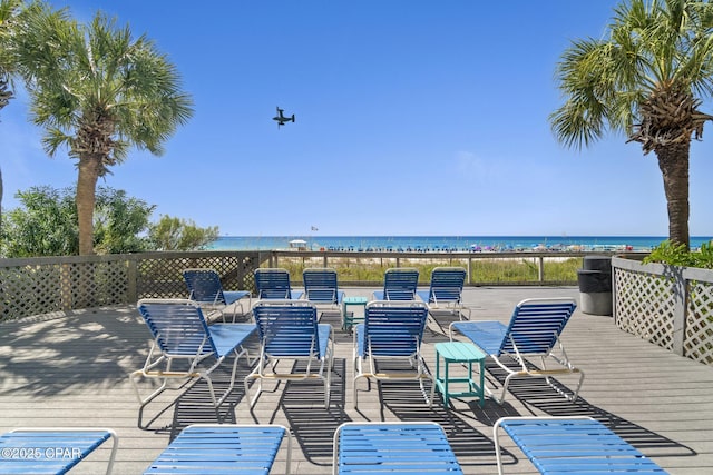 wooden deck featuring a view of the beach and a water view