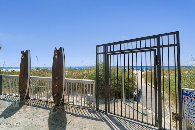 view of gate featuring a view of the beach and a water view