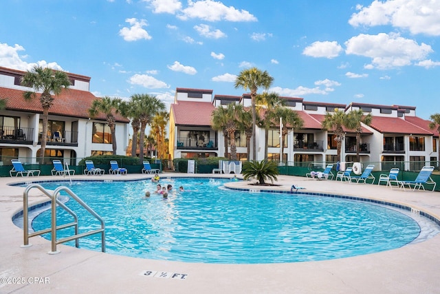 pool with a patio area and fence