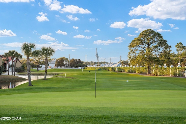 view of home's community featuring a lawn and view of golf course