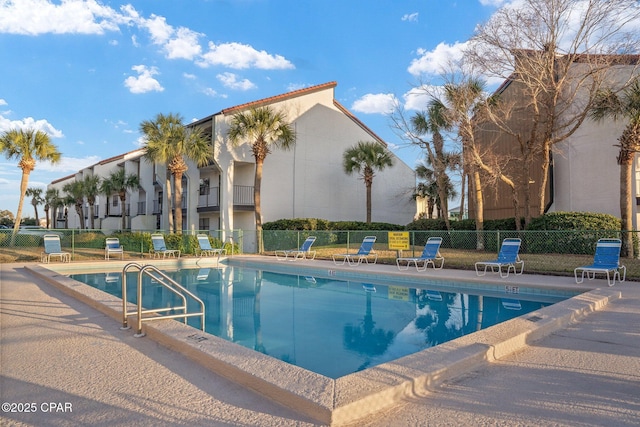 community pool featuring a patio area and fence