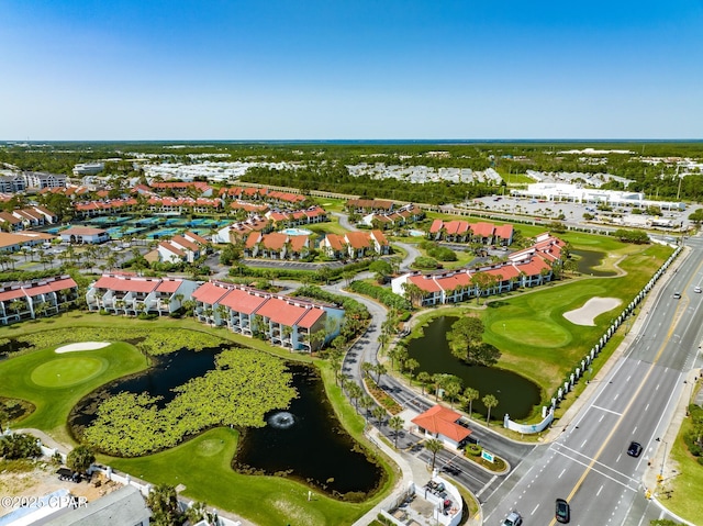 drone / aerial view with golf course view and a water view