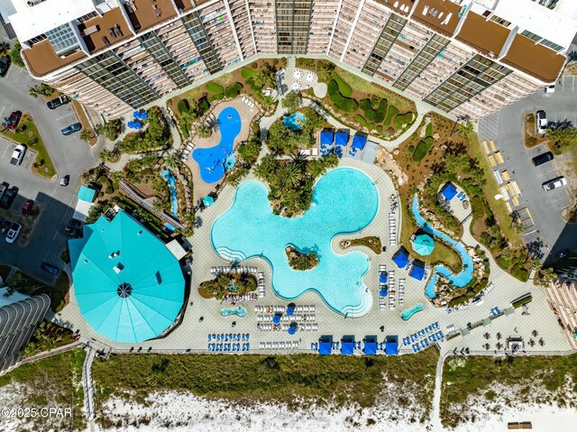 birds eye view of property featuring a beach view and a water view