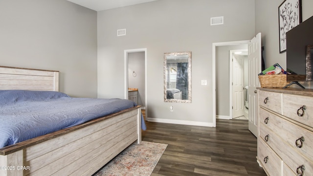 bedroom with high vaulted ceiling, dark wood finished floors, visible vents, and baseboards