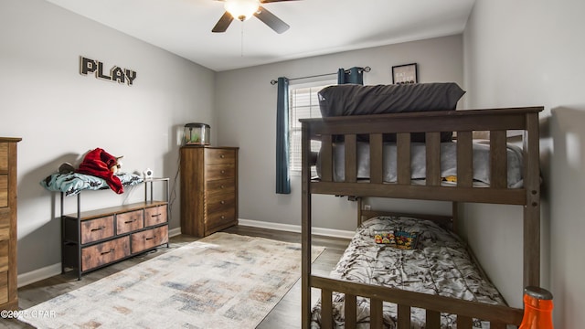 bedroom featuring a ceiling fan, baseboards, and wood finished floors