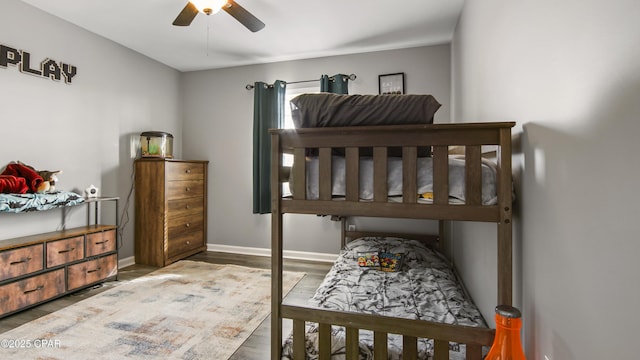 bedroom with ceiling fan, baseboards, and wood finished floors