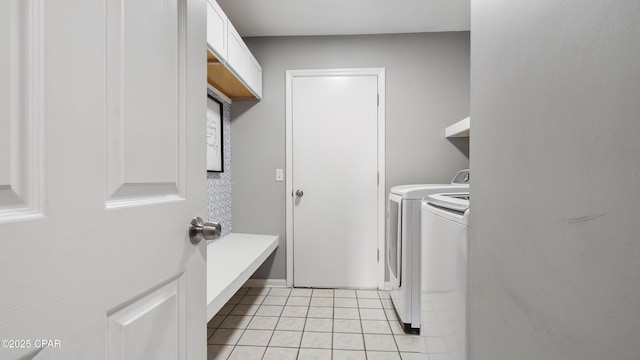 washroom featuring washing machine and dryer, laundry area, and light tile patterned floors