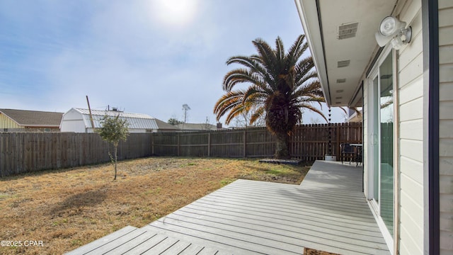 wooden terrace with a lawn and a fenced backyard