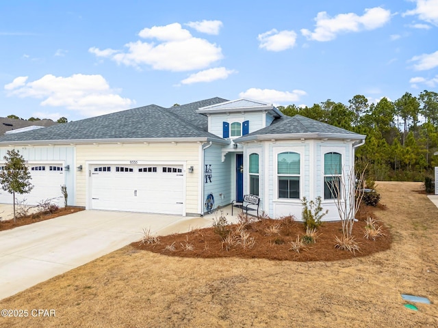 view of front of home with driveway, an attached garage, and a shingled roof