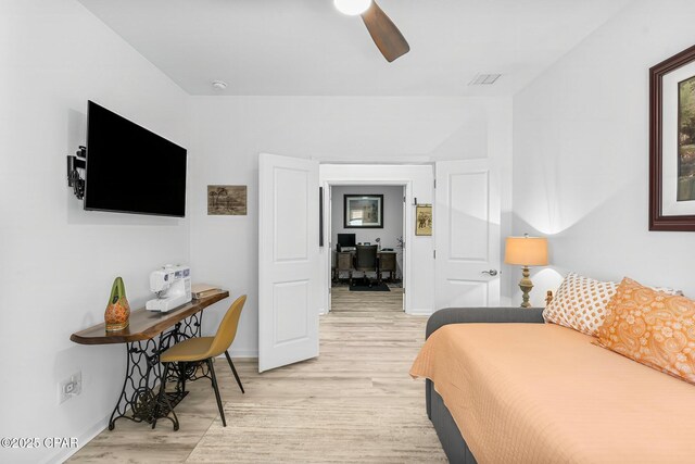 bedroom featuring light wood-style floors, baseboards, visible vents, and ceiling fan