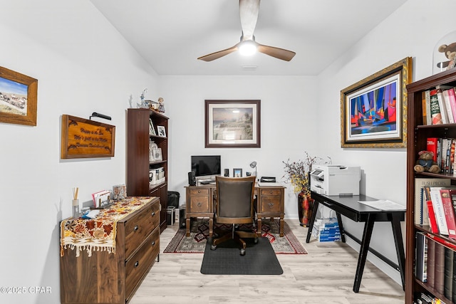 home office featuring visible vents, light wood-style flooring, and a ceiling fan