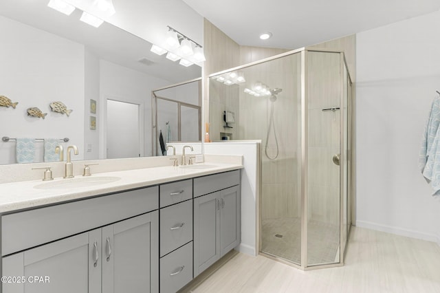 bathroom with a sink, double vanity, and a shower stall