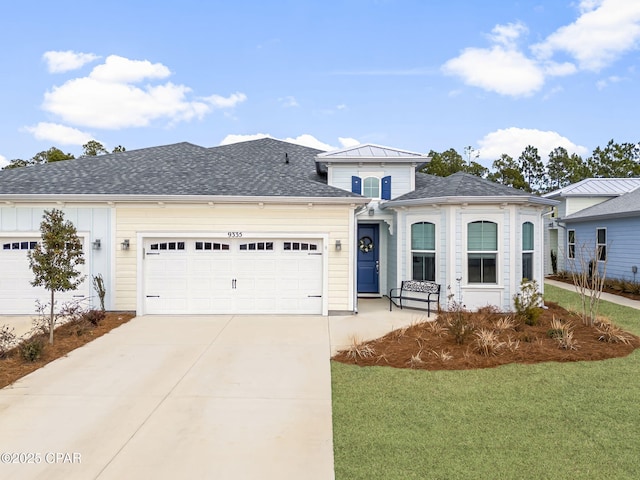 view of front facade featuring a front yard, driveway, a garage, and roof with shingles