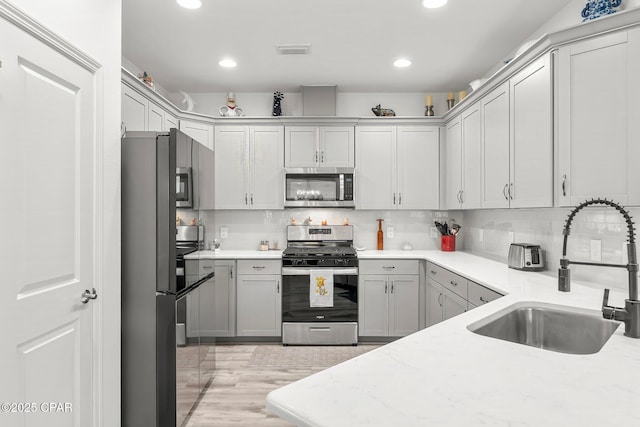 kitchen featuring visible vents, recessed lighting, a sink, stainless steel appliances, and backsplash