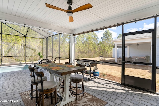 sunroom / solarium featuring ceiling fan