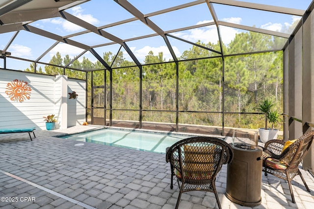 outdoor pool featuring glass enclosure and a patio