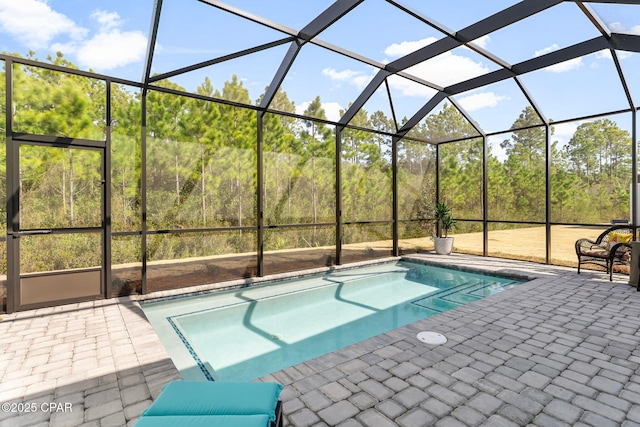 view of swimming pool featuring a patio area and glass enclosure