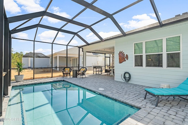 outdoor pool with a patio area and glass enclosure