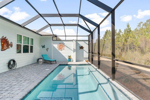 outdoor pool featuring glass enclosure and a patio area