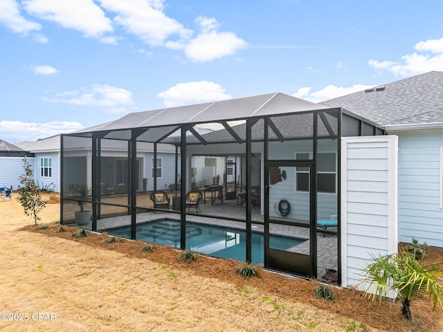 outdoor pool with glass enclosure and a patio area