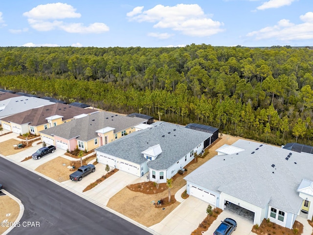 drone / aerial view featuring a residential view and a forest view