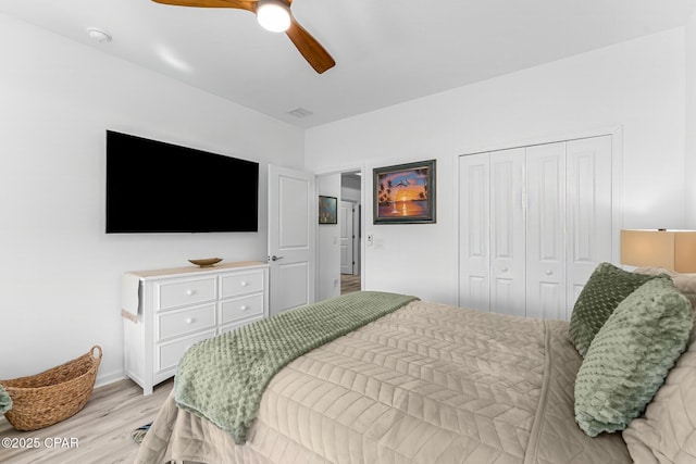 bedroom featuring a closet, light wood-style floors, and ceiling fan