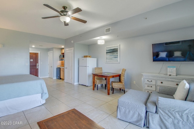 bedroom featuring white refrigerator, light tile patterned floors, and ceiling fan