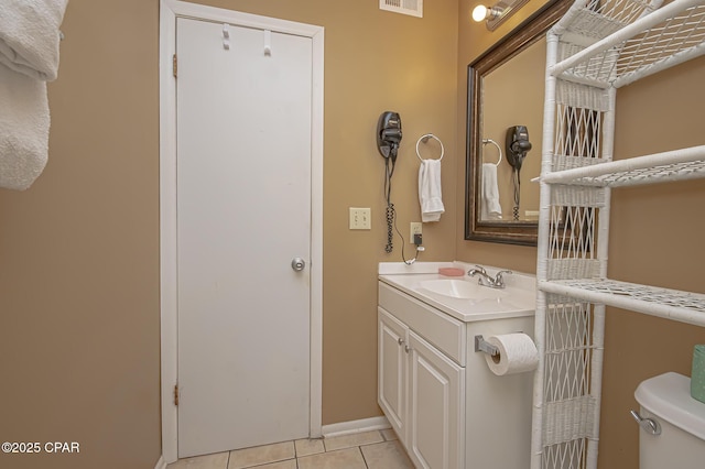 bathroom with tile patterned flooring, vanity, and toilet