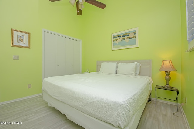 bedroom featuring ceiling fan, light hardwood / wood-style floors, and a closet