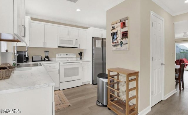 kitchen featuring ornamental molding, a sink, white appliances, white cabinets, and light countertops