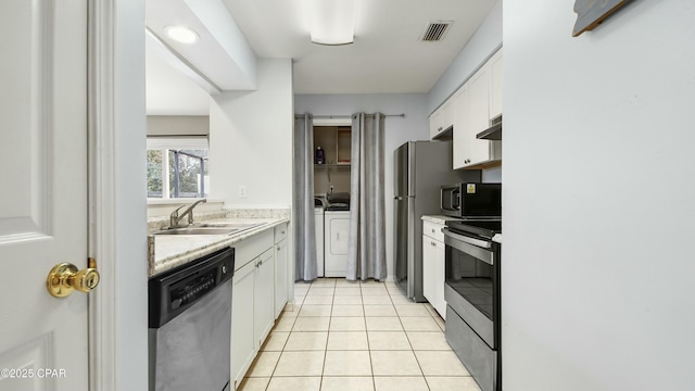 kitchen featuring light tile patterned flooring, sink, washer and dryer, stainless steel appliances, and white cabinets