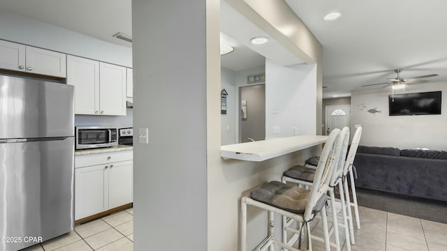 kitchen featuring light tile patterned floors, white cabinets, and appliances with stainless steel finishes