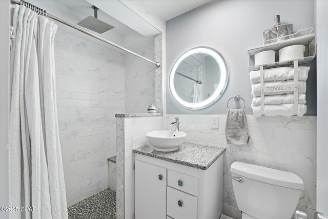 bathroom with tile walls, vanity, a shower with curtain, and toilet