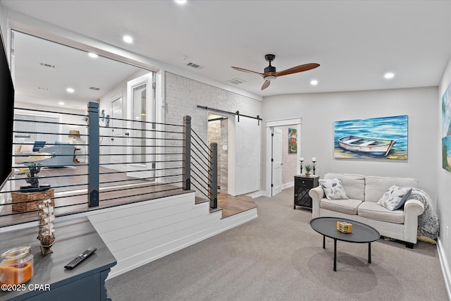 living room featuring a barn door, light carpet, and ceiling fan