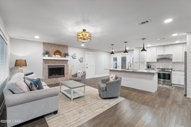 living room featuring hardwood / wood-style flooring, sink, and a fireplace