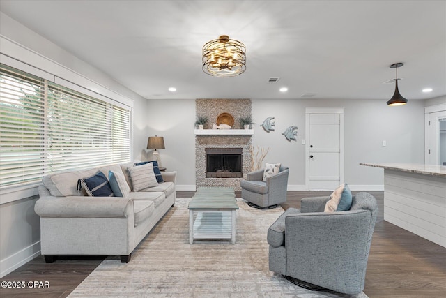 living room with hardwood / wood-style flooring and a large fireplace