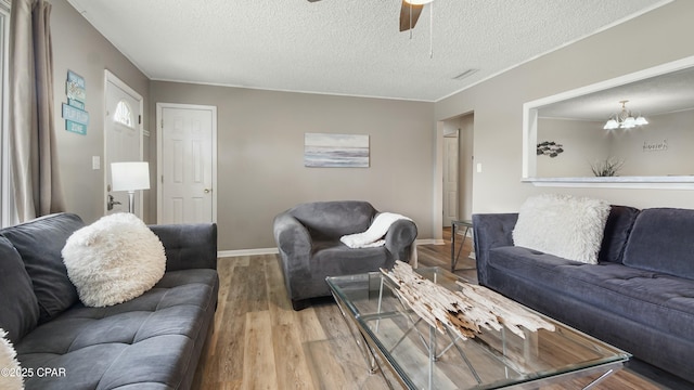 living room featuring light tile patterned floors, crown molding, a textured ceiling, and ceiling fan