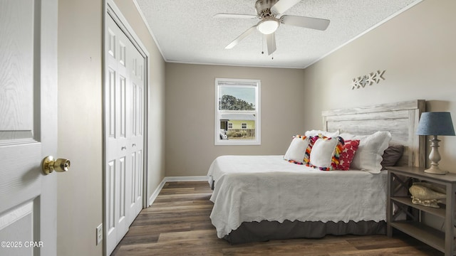 bedroom with dark wood-type flooring, a closet, crown molding, and a textured ceiling