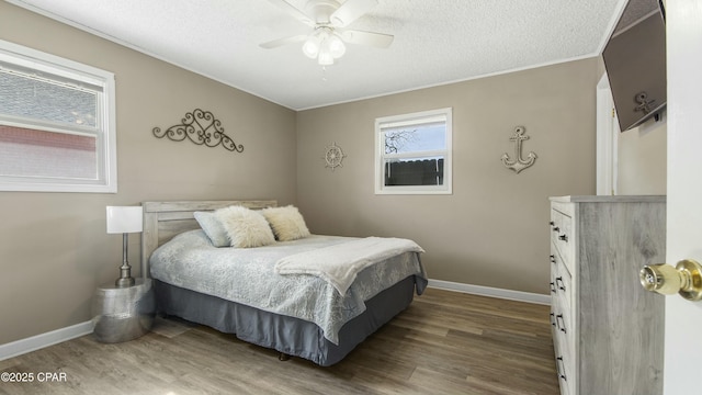 bedroom featuring ceiling fan, hardwood / wood-style floors, and a textured ceiling