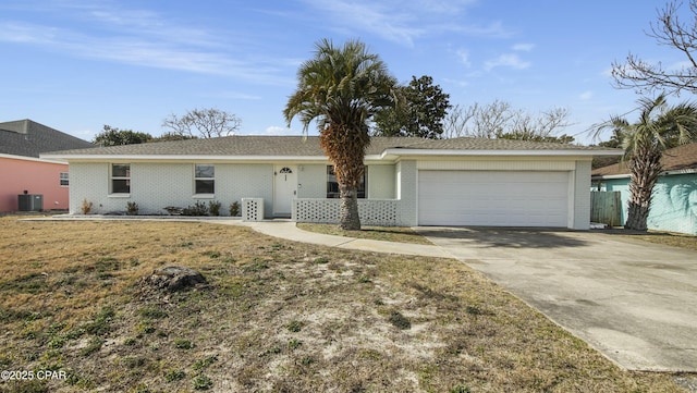 ranch-style house featuring central AC, a garage, and a front lawn