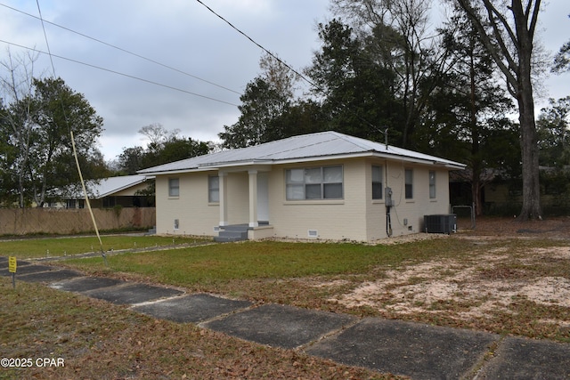 exterior space featuring cooling unit, crawl space, metal roof, a front yard, and fence