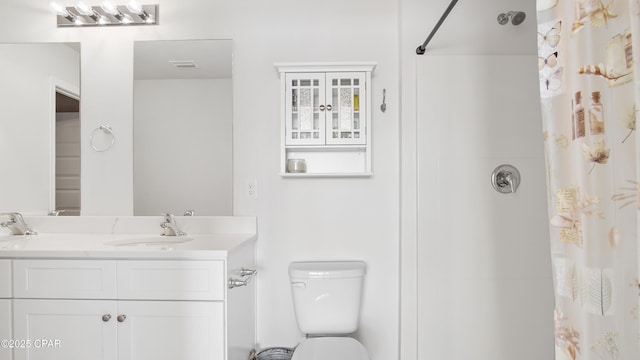 bathroom featuring vanity, toilet, and curtained shower