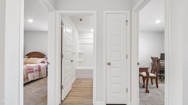 hallway featuring light colored carpet