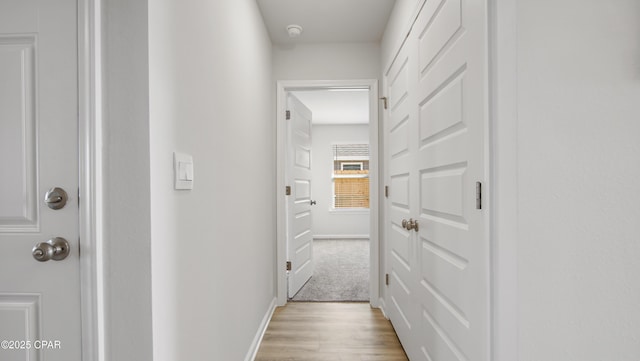 corridor with light hardwood / wood-style floors