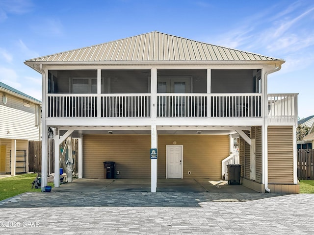 coastal inspired home with a carport and a sunroom