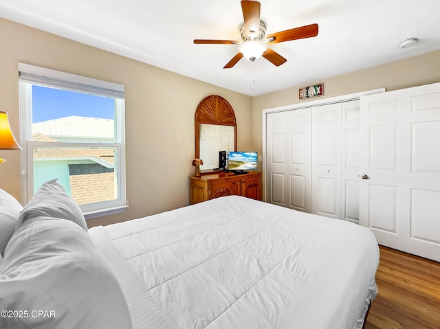 bedroom with ceiling fan, hardwood / wood-style floors, and a closet