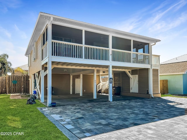 rear view of house with a carport and a sunroom