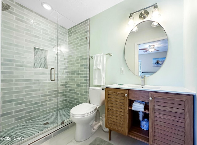 bathroom with vanity, a shower with door, and toilet