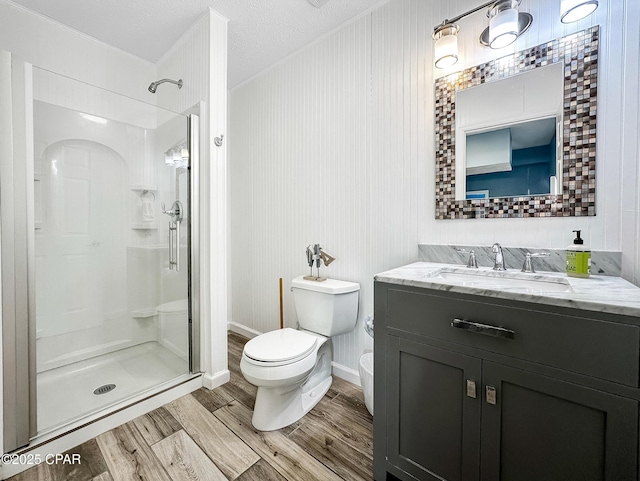 bathroom with an enclosed shower, hardwood / wood-style floors, vanity, and toilet