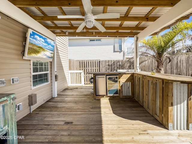 deck featuring ceiling fan, beverage cooler, and an outdoor bar